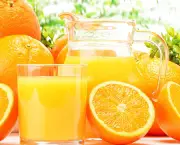 Glass and jug of orange juice and fruits